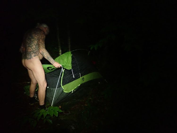 Naked Hiking Day in Vermont: ...sein Zelt aufbauend, aufgenommen vom Licht eines Scheinwerfers.