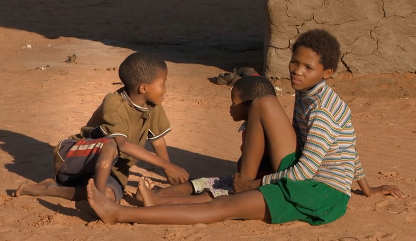 Kinder eines Stamms der Buschmänner in Namibia. Man trägt Shorts und T-Shirts