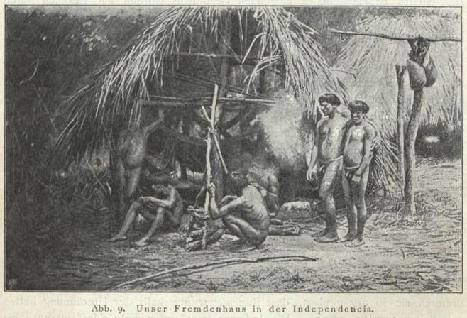 In der indigenen Dorfgemeinschaft bekam der Forschungsreisende Karl von den Steinen ein Fremdenhaus zur Verfügung gestellt. Zwei der Männer tragen eine Hüftschnur, einer hockt auf dem Boden, ein anderer sitzt auf dem Boden.
